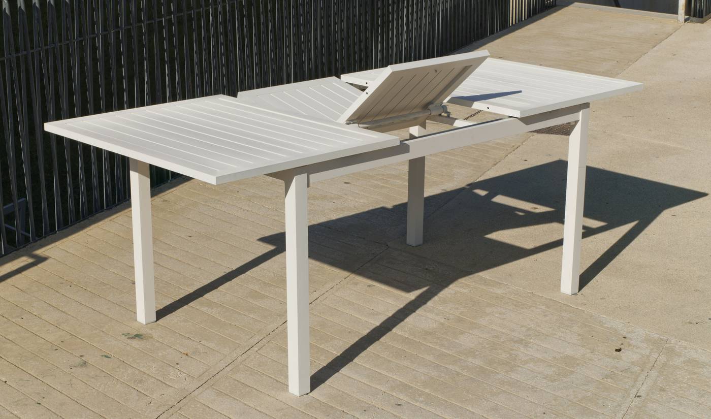 Mesa rectangular extensible de aluminio  con tablero lamas de aluminio. Disponible en color blanco, antracita o champagne.